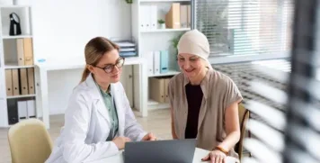 Functional medicine practitioner reviewing a personalized cancer recovery plan on a laptop with a patient.